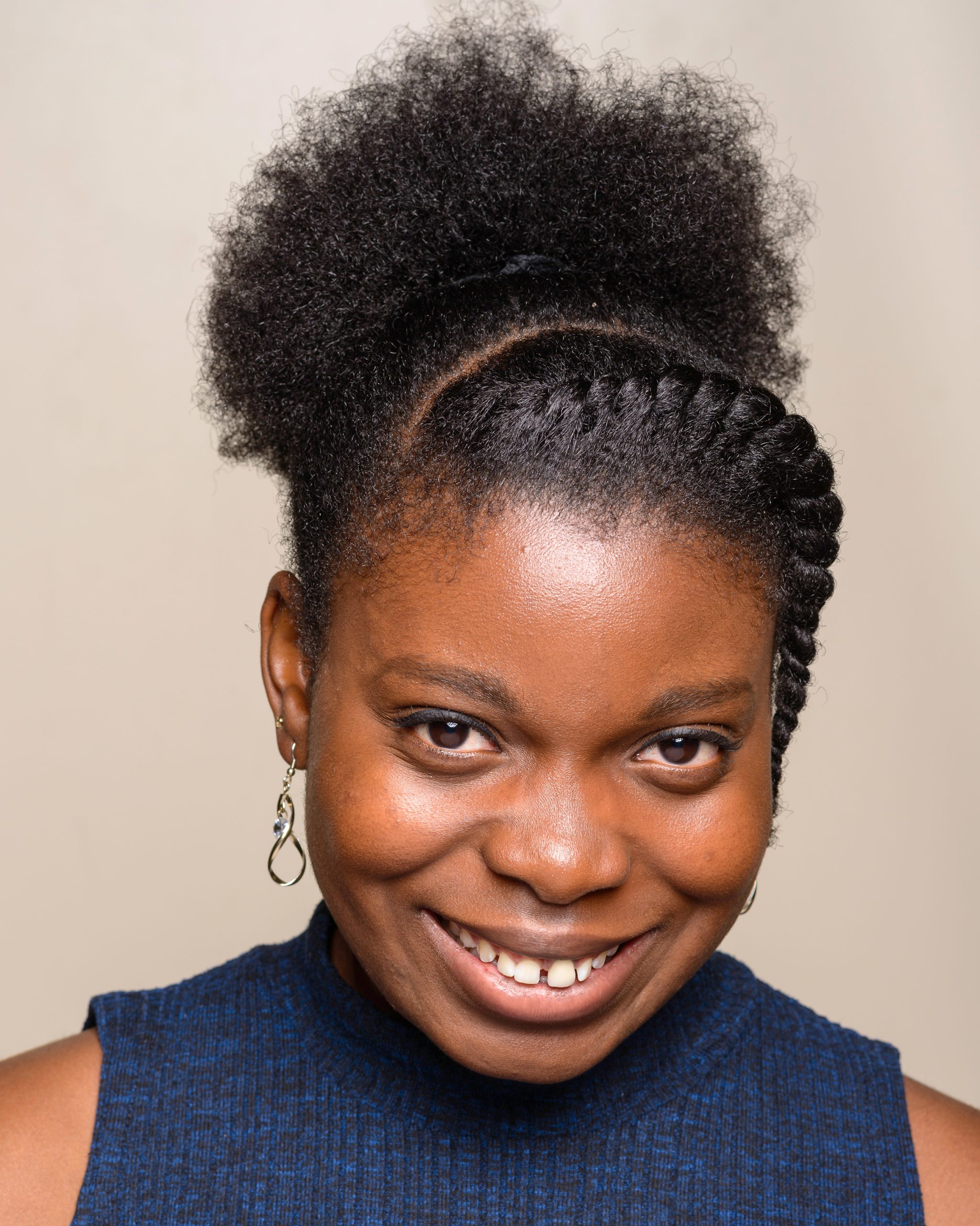 Justina's headshot - they're smiling, wearing a blue top